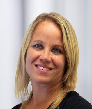 Blonde woman smiling, head tilted