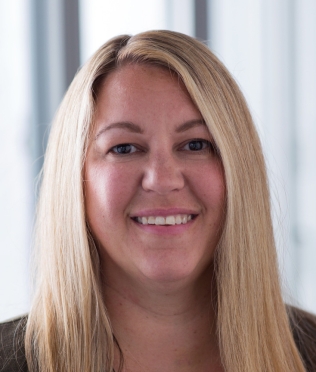 Blonde woman smiling, head tilted